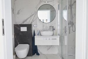 a bathroom with a toilet and a sink and a mirror at Przestronny Apartament in Ostrów Wielkopolski +6 photos