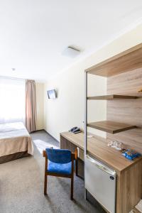 a bedroom with a bed and a desk and a chair at Nikotel Hotel Mykolaiv in Mykolaiv