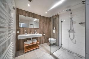 a bathroom with a sink and a shower and a toilet at Apartments Four Seasons Zuiderstraat in Egmond aan Zee