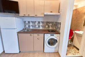 a small kitchen with a washing machine and a sink at Stanford Apartments Gara de Nord in Bucharest