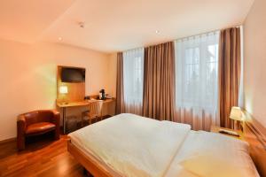 措芬根Apart Hotel Amadeo的配有床和书桌的酒店房间