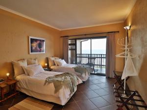 a hotel room with two beds and a balcony at Timeless Lodge in Umkomaas