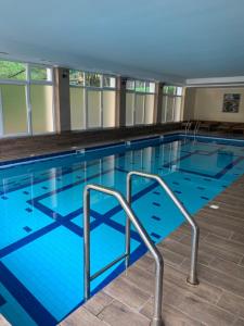 a large indoor swimming pool with blue water at Апартаменты LUXURY LAVANDER in Polyana