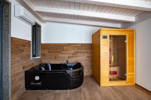 a room with a wooden floor and a tub at Hotel La Compagnia Del Viaggiatore in LʼAquila
