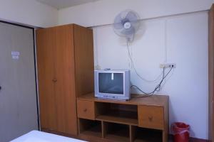Habitación con TV en un tocador con ventilador en Water Well Guest House, en Chiang Mai
