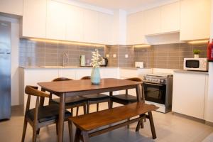 a kitchen with a wooden table and chairs and a kitchen with a microwave at GuestReady - Flutes of Harmony in Town Square in Dubai