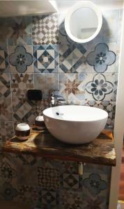 un bagno con lavandino bianco su un bancone in legno di B&B La Casetta a Castellaneta