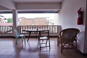 uma varanda com uma mesa e cadeiras e um extintor de incêndio em Water Well Guest House em Chiang Mai