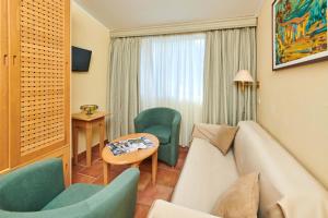 a hotel room with a couch and chairs and a table at Apartments Bellevue Plava Laguna in Poreč