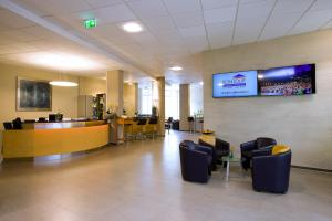 a lobby with a waiting room and a tv on the wall at bonjour Tagungshotel Stuttgart-Gerlingen in Gerlingen