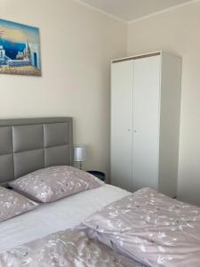 a bedroom with a bed and a white cabinet at Przestronny Apartament in Ostrów Wielkopolski