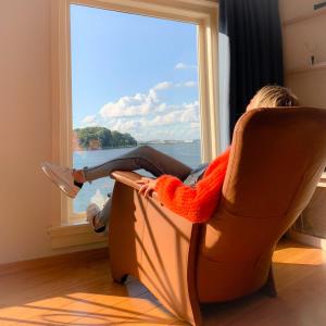 un niño sentado en una silla mirando por la ventana en All Exclusive Apartments en Dordrecht