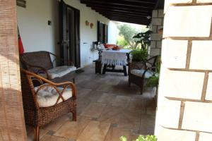 un patio con sillas y una mesa en una habitación en Villa di campagna vicino al mare, en Orosei