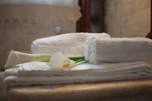 a pile of towels and a flower on a table at Villa di campagna vicino al mare in Orosei