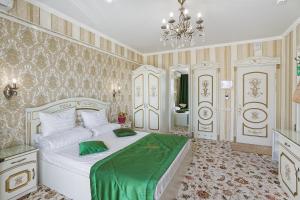 een slaapkamer met een groot wit bed met groene lakens bij Villa Valentina in Alushta