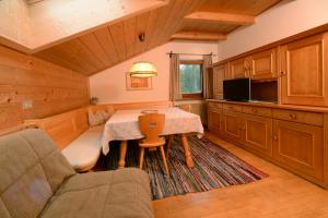 uma sala de jantar com uma mesa e um sofá em Apartment Puciacia - Bauernhof em Santa Cristina in Val Gardena