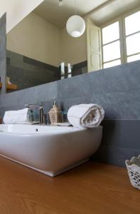 bagno con lavandino bianco e specchio di Residenza d'Epoca Regina d'Arborea a Oristano