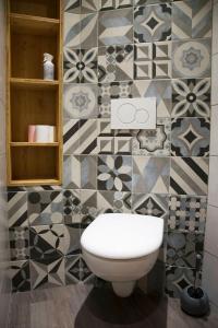 a bathroom with a toilet and a tiled wall at Appartement 3 étoiles - au pied des pistes in Valmeinier