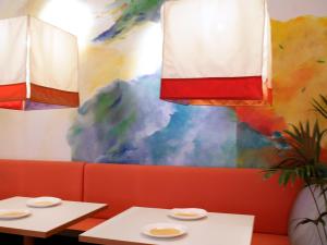 two tables in a restaurant with a colorful wall at 1st Creatif Hotel Elephant in Munich