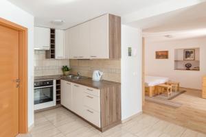 cocina con armarios blancos y encimera en Apartment house Jager en Bohinj