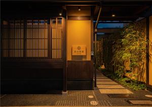 une entrée à un bâtiment avec un panneau sur celui-ci dans l'établissement 谷町君・星屋・談山旅館　京都嵐山, à Shimo-saga