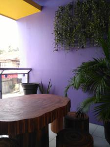 Habitación con mesa de madera y pared púrpura. en Bohol Coop Tourist Inn, en Tagbilaran City