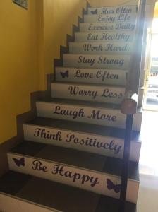 a stairwell with a happy staircase with words on it at Bohol Coop Tourist Inn in Tagbilaran City