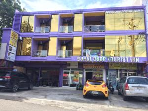 een gele auto geparkeerd voor een gebouw bij Bohol Coop Tourist Inn in Tagbilaran-stad