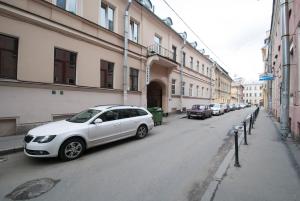 a white car parked on a street next to buildings at Kolman Apart in Saint Petersburg