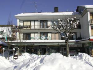 budynek z kupą śniegu przed nim w obiekcie Gästehaus Café Heck Titisee w mieście Titisee-Neustadt