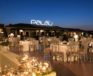 a group of tables and chairs with white table cloths at Hotel Palau in Palau