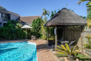 a resort with a swimming pool and a gazebo at Ruslamere Hotel and Conference Centre in Durbanville