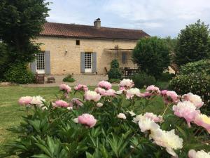 een tuin met roze bloemen voor een huis bij Le Clos de Longas - Gite et Chambre d'hôtes in Sainte-Foy-de-Longas