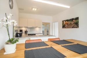 a dining room table with chairs and a kitchen at Ferienwohnung 4 am Biohof Eriskirch in Eriskirch