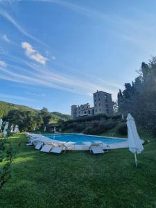 - une piscine avec un bouquet de chaises et un parasol dans l'établissement Badia San Nicolò di Campolongo - Appartamento D'Onofrio, à Valfabbrica