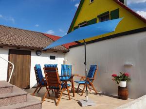 einen Tisch mit Stühlen und einem Sonnenschirm auf einer Terrasse in der Unterkunft Ferienwohnungen Schwarzwaldhäusle in Freudenstadt