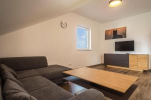 uma sala de estar com um sofá e uma mesa em Ferienwohnung 3 am Biohof Eriskirch em Eriskirch