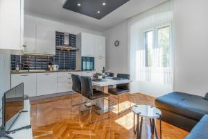 a kitchen and living room with a table and chairs at Apartmani Dada in Rijeka