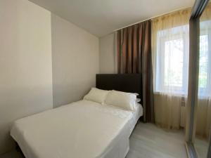 um quarto com uma cama branca e uma janela em 3-bedroom apartment Most City area em Dnipro