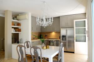 a kitchen with a white table and a chandelier at Olive Beach Forte dei Marmi in Forte dei Marmi
