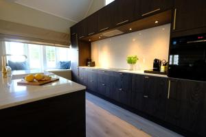 a kitchen with dark wood cabinets and a counter top at Sjøgata Gjestehus in Larvik