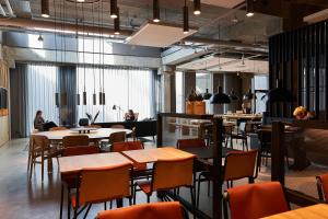 a restaurant with tables and chairs and people sitting at tables at Zleep Hotel Lyngby in Kongens Lyngby