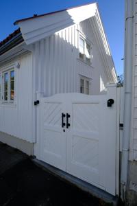 a white garage with a white door and a building at Sjøgata Gjestehus in Larvik