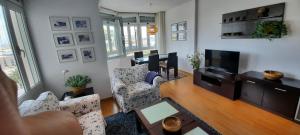 a living room with a couch and a tv at Isamaría Parque Santa Catalina in Las Palmas de Gran Canaria