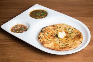 un plato blanco con un bagel y dos salsas de inmersión en Hotel Kings, en Amritsar