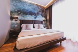 a bedroom with a large bed with a painting on the wall at Callistos Hotel & Spa in Tricase