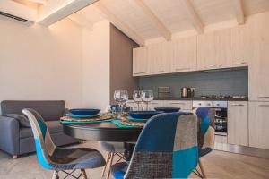 a dining room with a table with chairs and wine glasses at Controvento in La Maddalena