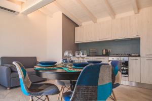 una sala da pranzo con tavolo, sedie e bicchieri da vino di Controvento a La Maddalena