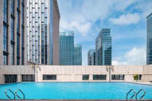 a swimming pool in a city with tall buildings at Zhuhai Hengqin Qianyuan Hotel in Zhuhai