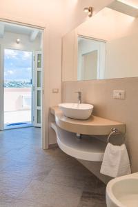 a bathroom with a sink and a mirror at Controvento in La Maddalena